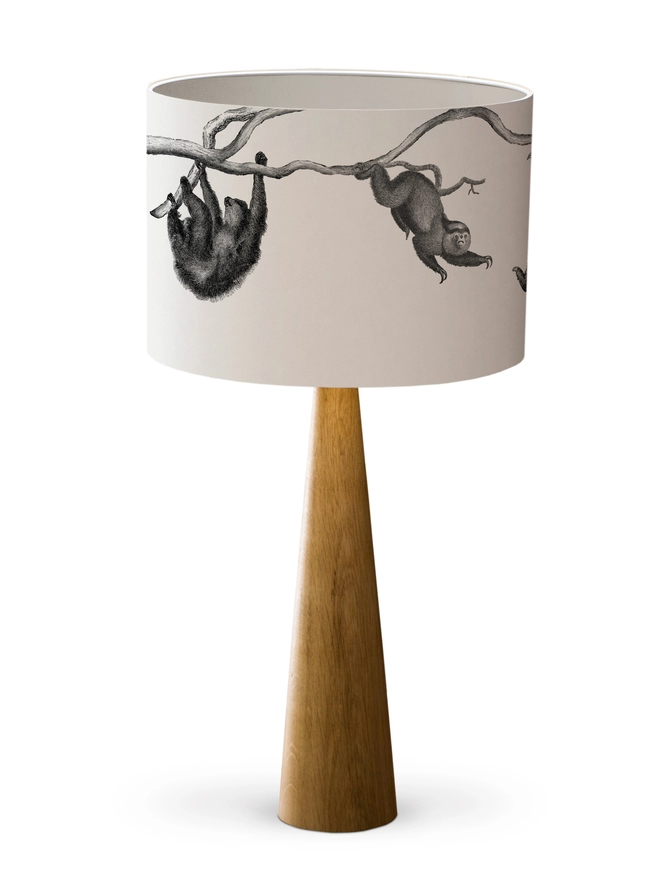 Drum Lampshade featuring Sloths with a white inner on a wooden base on a white background