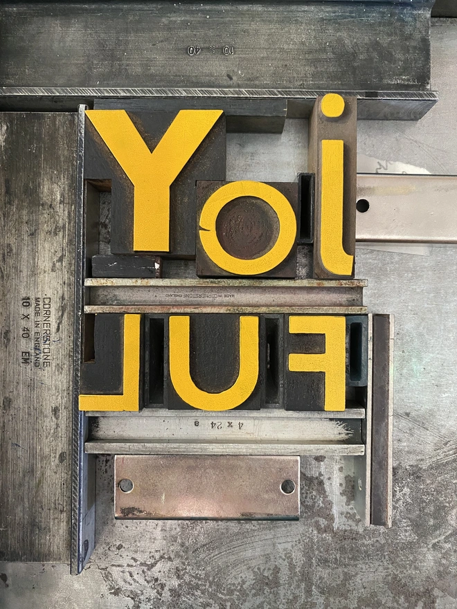 Wood type inked in yellow - joyful