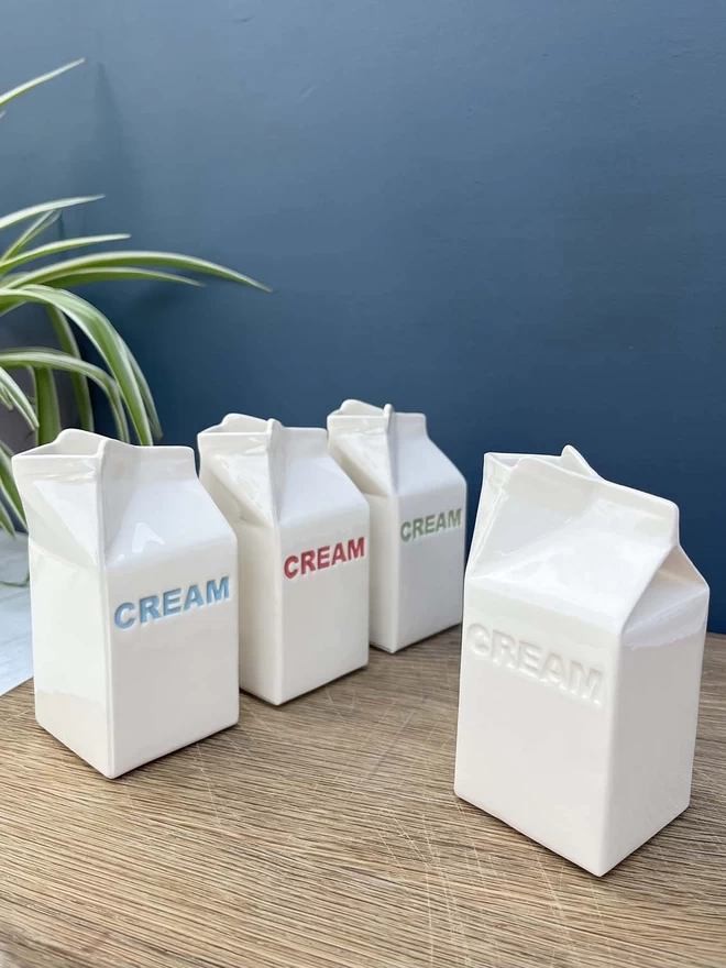 4 handmade cream cartons shows the different colours the lettering can be - blue, red, green or plain.