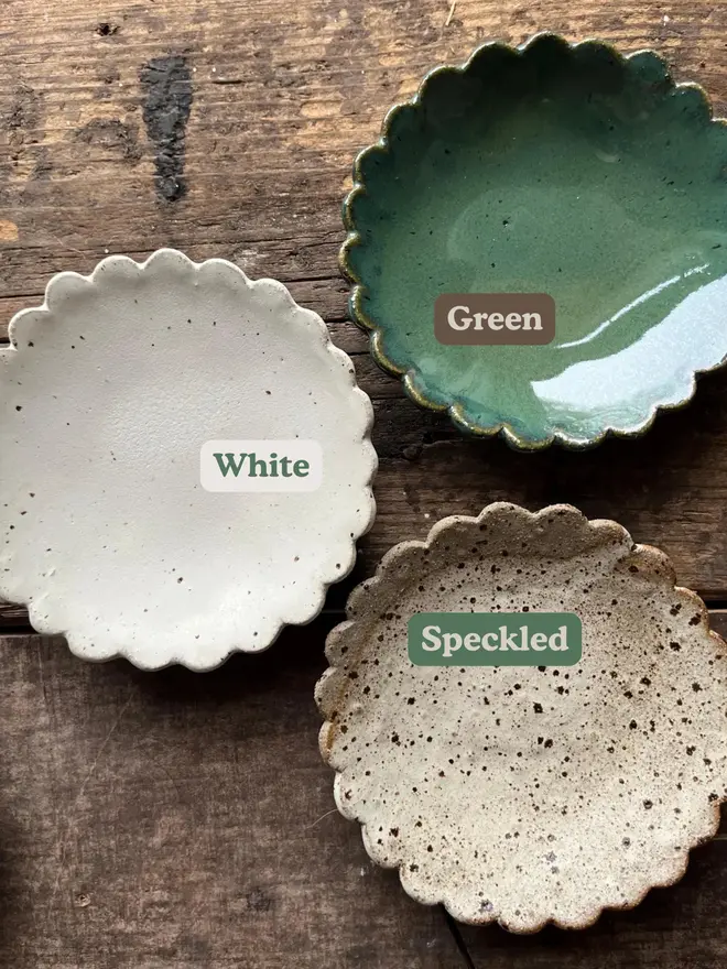 Handmade Scalloped Ceramic Dish, a collection of colourful ceramic plates on a wooden surface.
