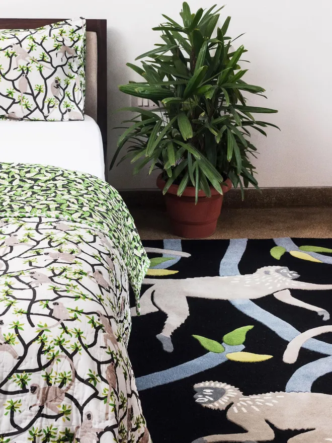 Langur Hand Tufted Rug, a monkey design rug sitting in a bedroom. It is accompanied by some bedroom accessories. 