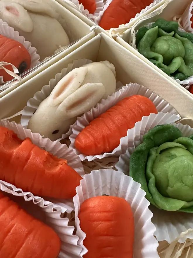 Marzi The Easter Bunny Marzipan, boxes of Marzi the Easter bunny marzipans grouped next to each other. In the boxes is the rabbit, carrots and kale. 