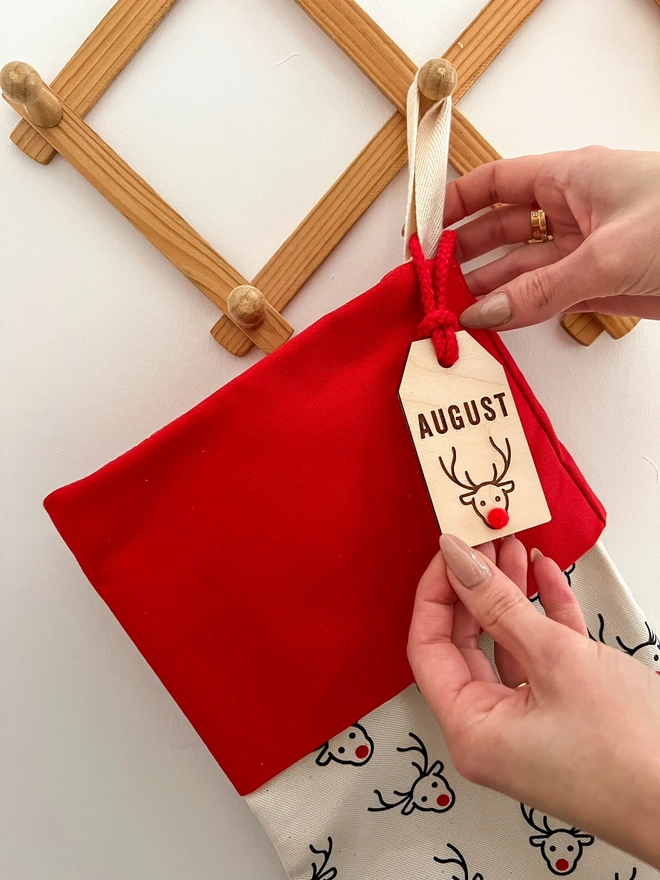 Birch ply personalised tag with Reindeer design on a red Christmas Stocking with matching print