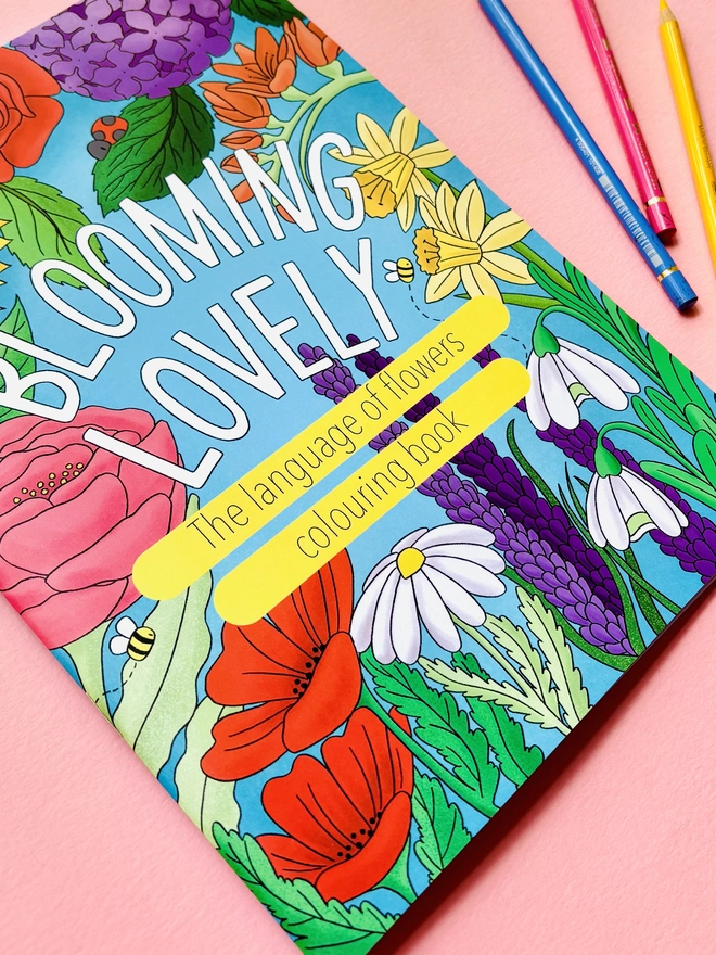 Illustrated a4 floral colouring book for adults and kids. A full colour cover reads ‘Blooming Lovely: the language of flowers colouring book’ surrounded by colourful wildflowers
