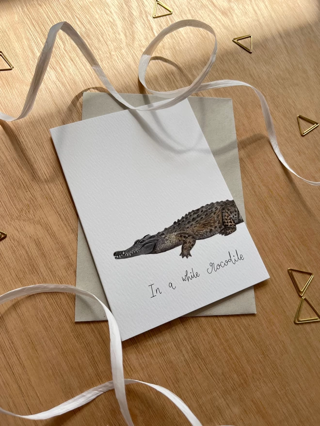 greetings card featuring an illustrated crocodile and the phrase “in a while crocodile”