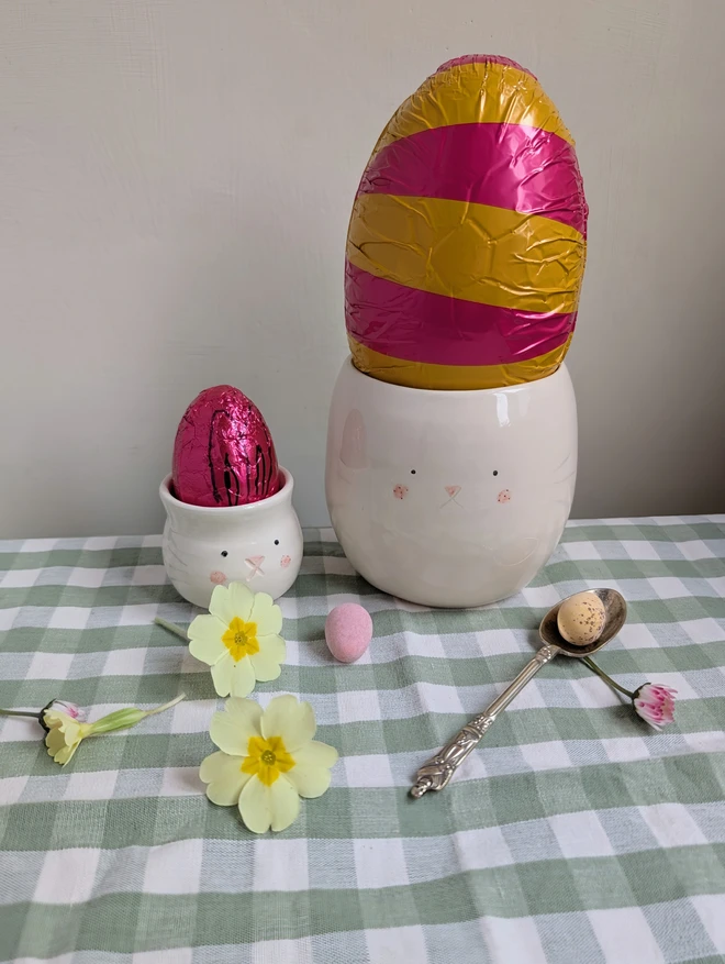 bunny beaker and egg cup with cute bunny face each with a bright Easter egg inside