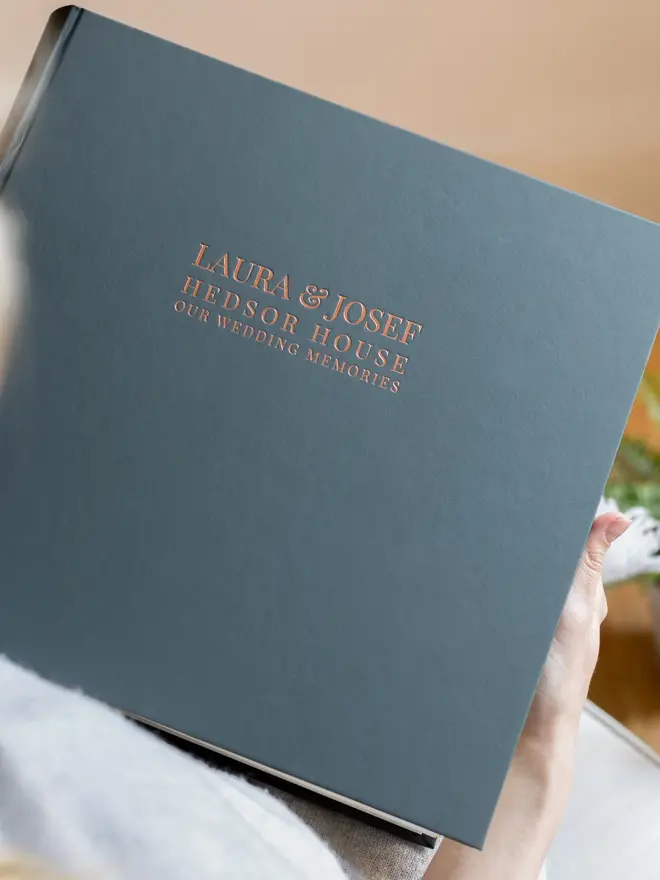 Beautifully Bespoke Large Wedding Photo Album, held in a person's arms. 