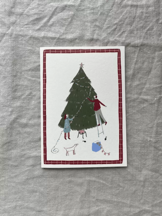 christmas card with people decorating the tree on 