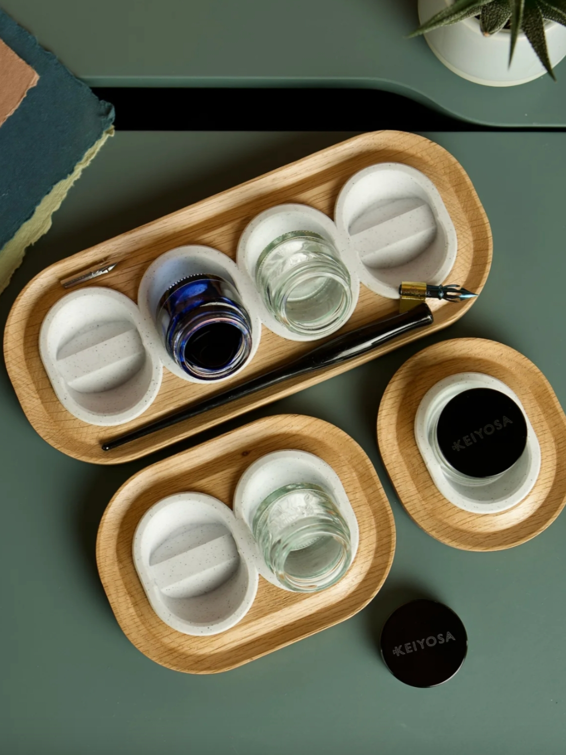 Versatilt Ink Stand. All sizes of pot holder are shown, with a single-pot holder, a two-pot holder, and a four-pot holder. They are in Marble White.