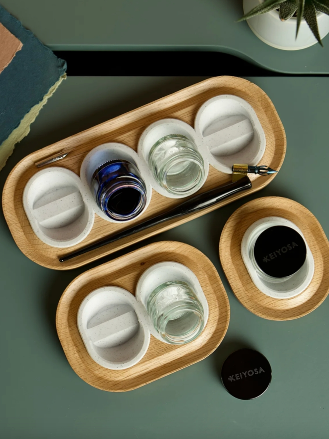 Versatilt Ink Stand. All sizes of pot holder are shown, with a single-pot holder, a two-pot holder, and a four-pot holder. They are in Marble White.