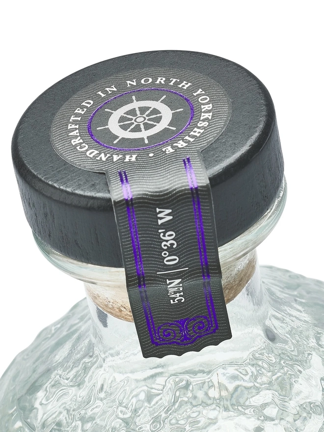 The Demeter Edition Gin, a bottle of gin sitting on a plain white surface. 
