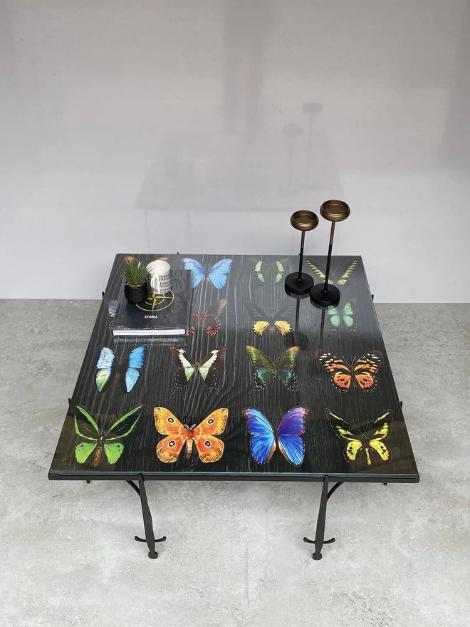 vibrant butterfly artwork sat on top of a metal frame coffee table