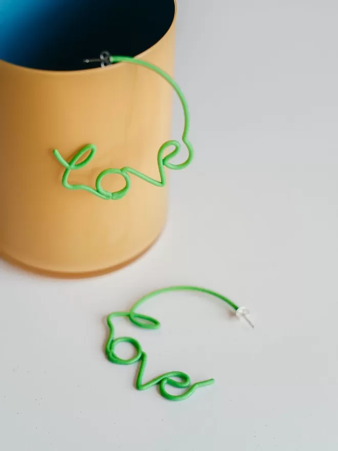 Large Green Love hoops seen in a yellow cup.