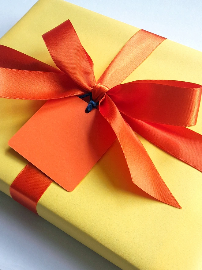 foiled heart hb pencil. yellow gift wrap with an orange bow.