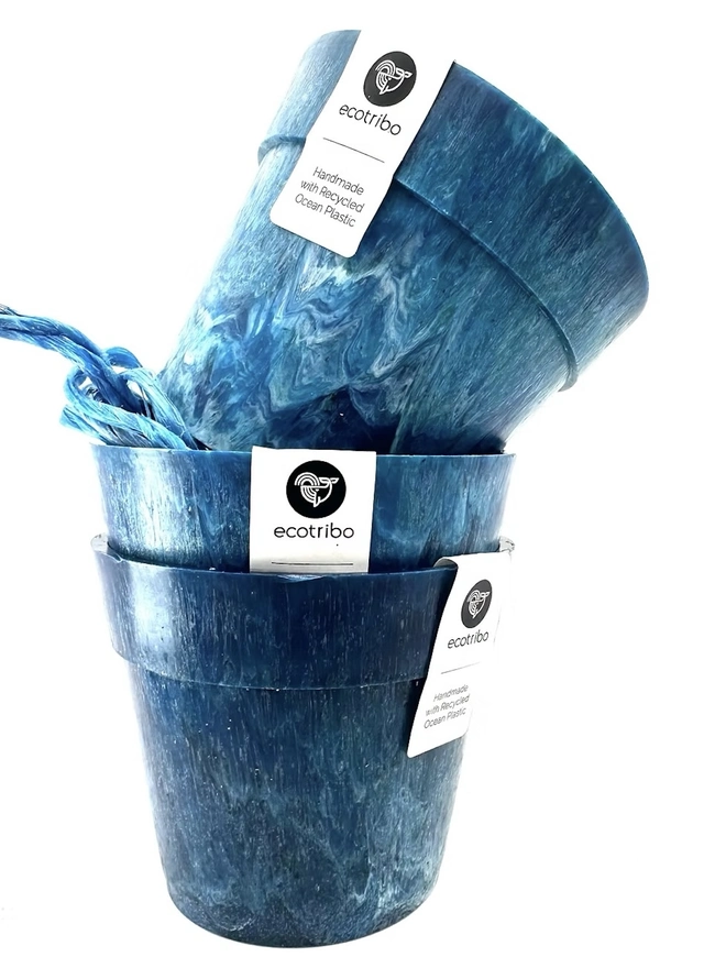 Small Blue Ocean Plastic Plant Pot , a collection of blue recycled pots sitting on a white surface against a plain backdrop. 