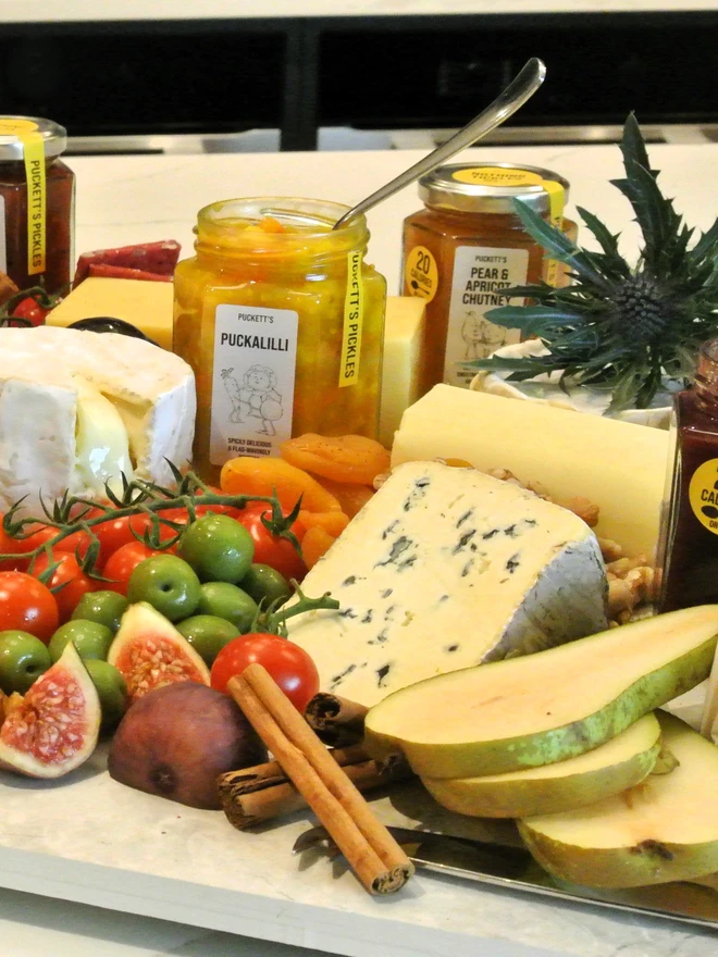 pear and apricot chutney. a cheeseboard featuring a selection of artisan pickle jars.