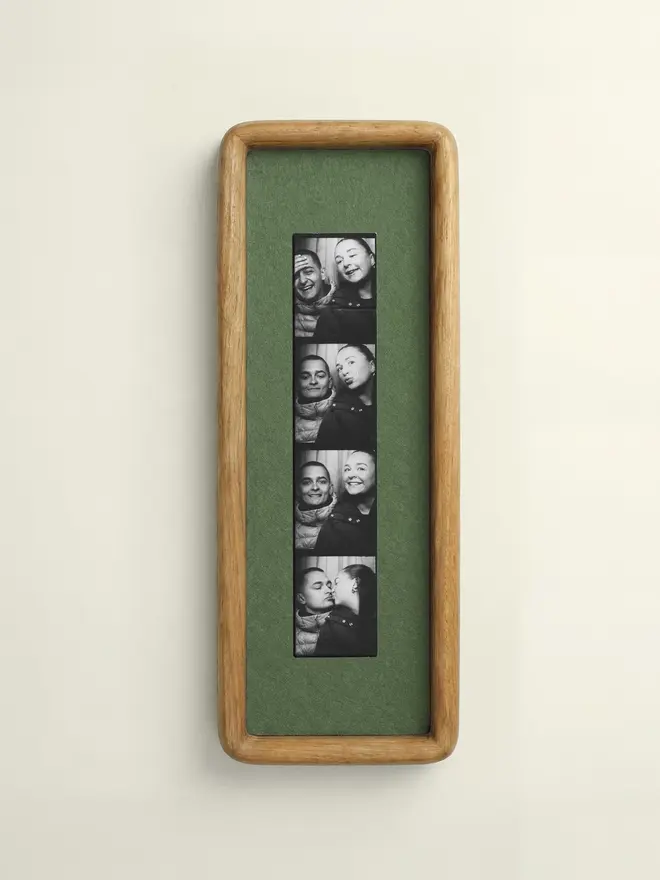 Mid Green Mounted Photobooth Solid Wood Frame, hanging on a white wall. 