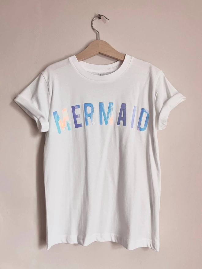 white T-shirt with iridescent MERMAID wording on the chest