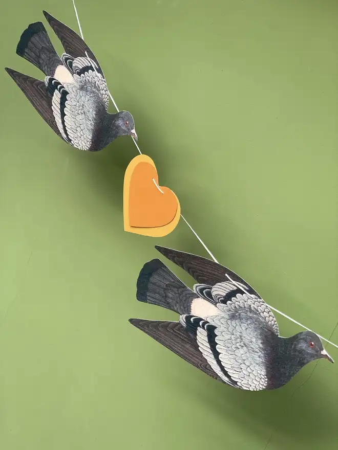 bunting made of hand cut paper pigeons and gold hearts