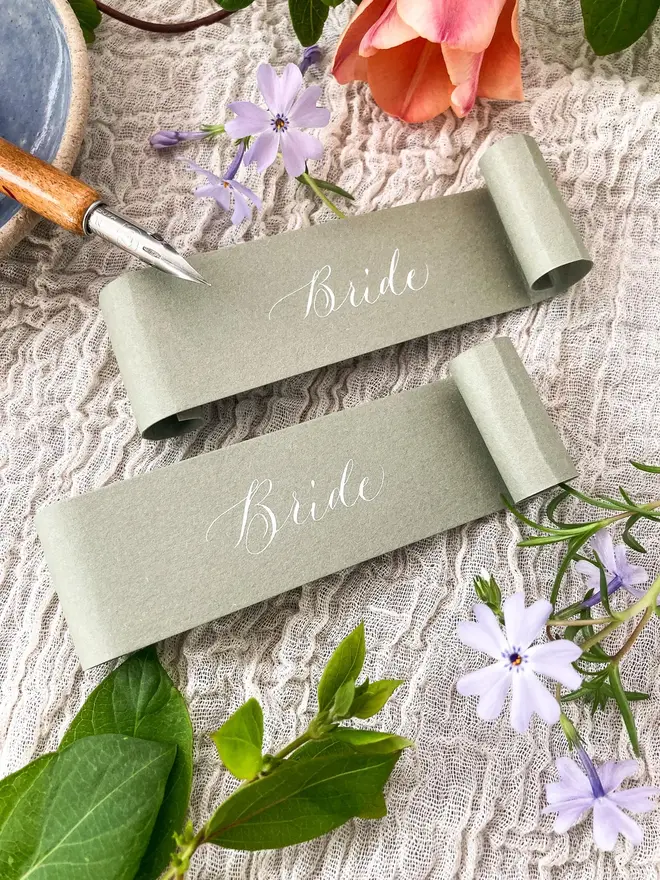 sage green scroll calligraphy wedding place cards. sage green scroll with white calligraphy.