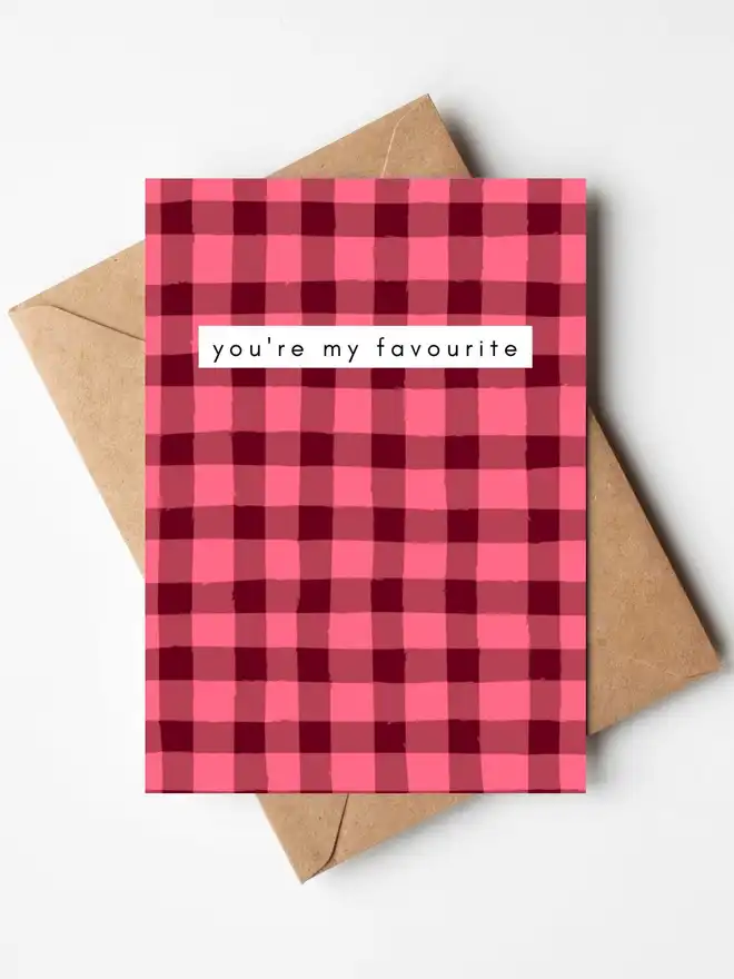 A pink gingham greeting card with the words "you're my favourite" across the centre. The card is displayed with a kraft envelope.