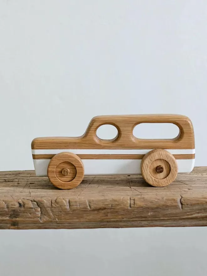 Wooden Toy Car Station Wagon in White side view of the toy on a wooden shelf