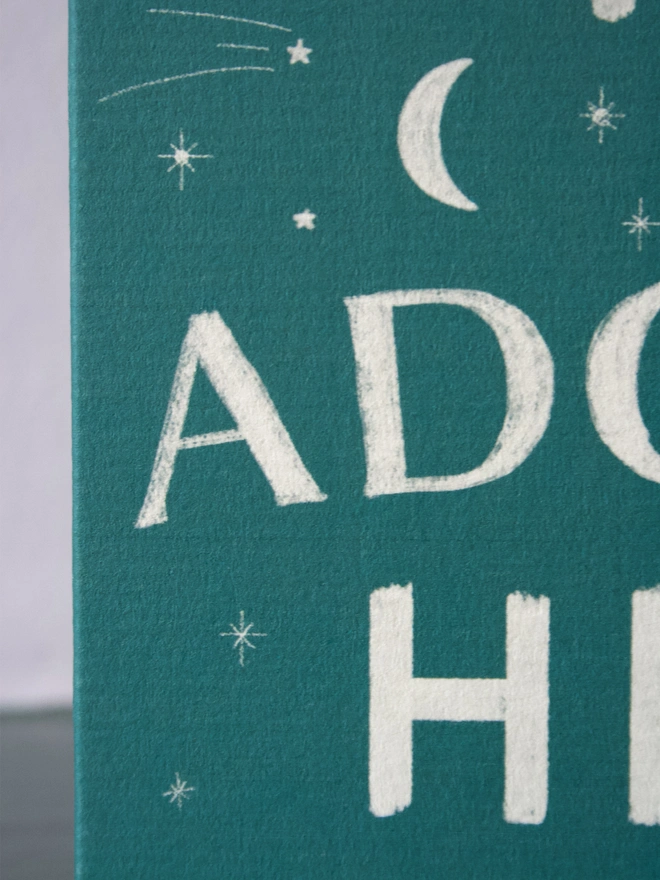 Green Christmas card with the words 'come let us adore him' on the front