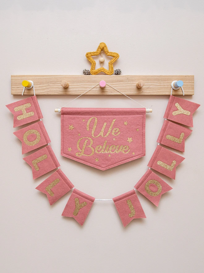 rose pink and champagne "We Believe" banner  hanging alongside some "Holly Jolly" Bunting