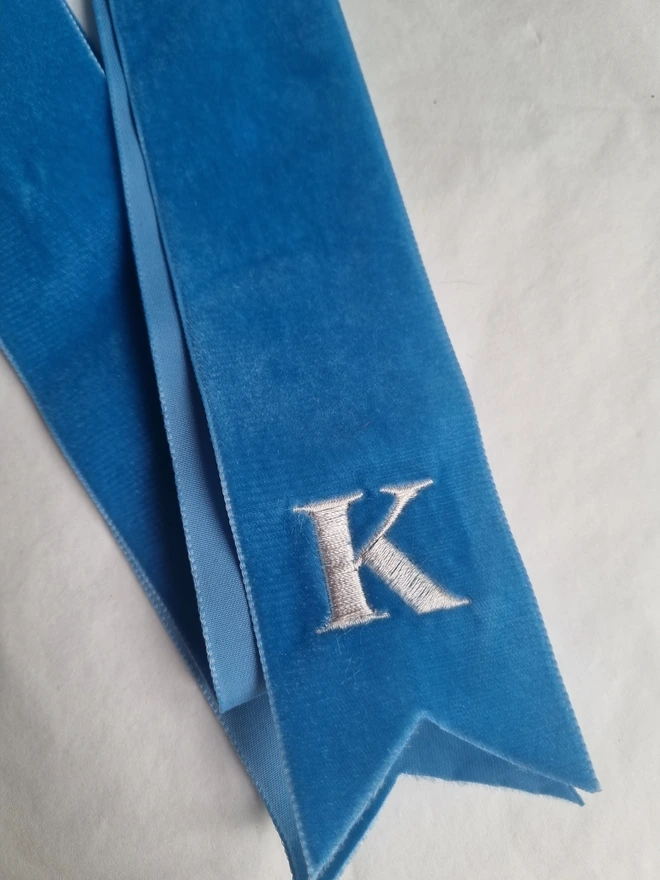 A Blue velvet ribbon embroidered with a K