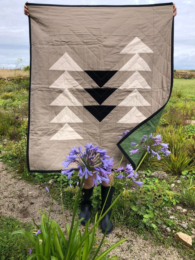 Flow Taupe Linen Throw Quilt. A natural quilt with bold geometric black & white triangle pattern. 