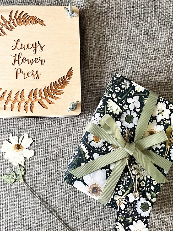 Black and white floral wrapping paper with a pressed flower design.