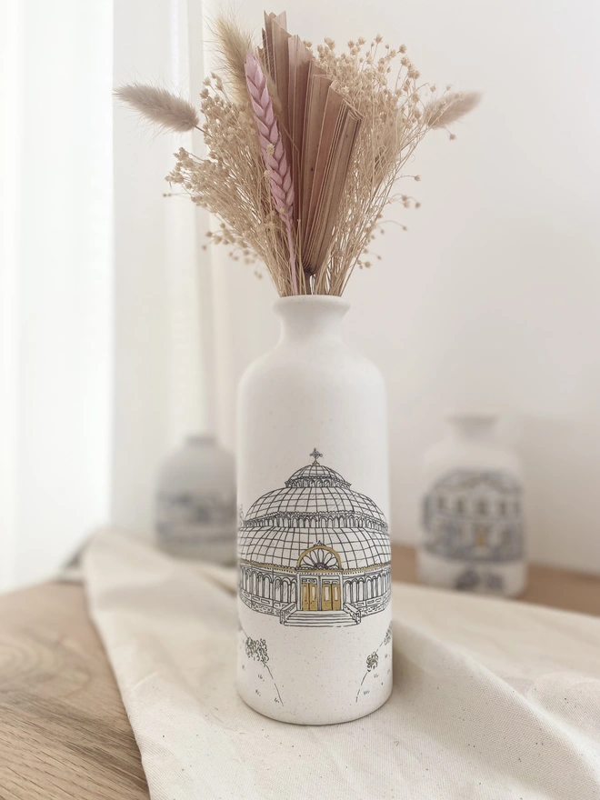 Ceramic vase with black hand drawn venue illustration featuring metallic gold highlights 