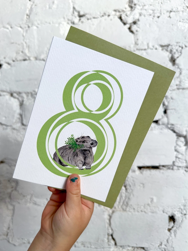 white card with a big green number 8 and a cute little pika illustration with a green envelope