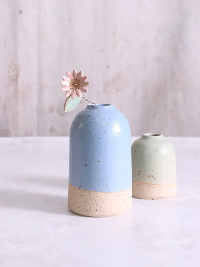 medium blue vase with ceramic pink daisy flower stem