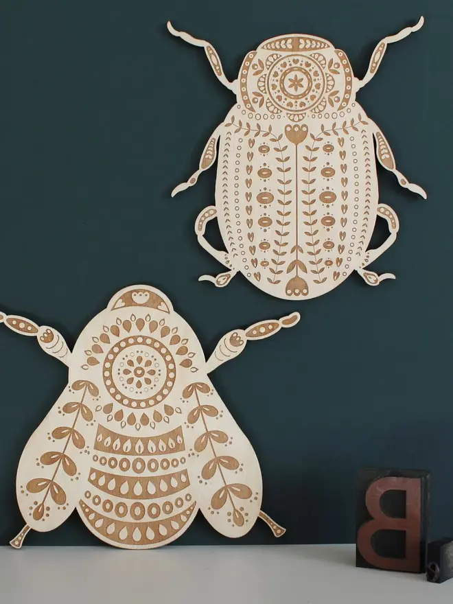 Folk Art Beetle Wall Hanging, wooden insect decoration hanging on a wall. 