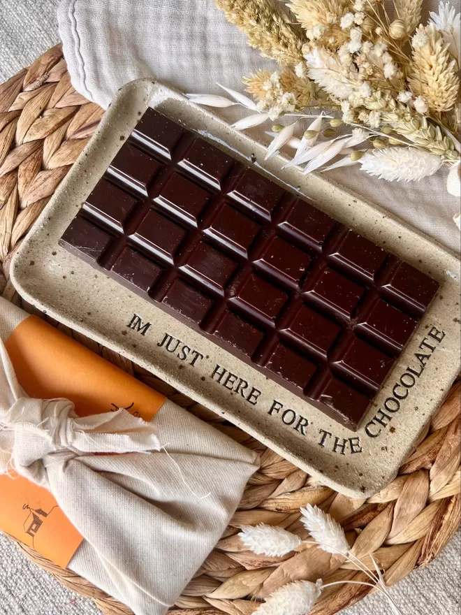 bar of chocolate on a rectangle ceramic plate, stamped with the words 'I'm just here for the chocolate'