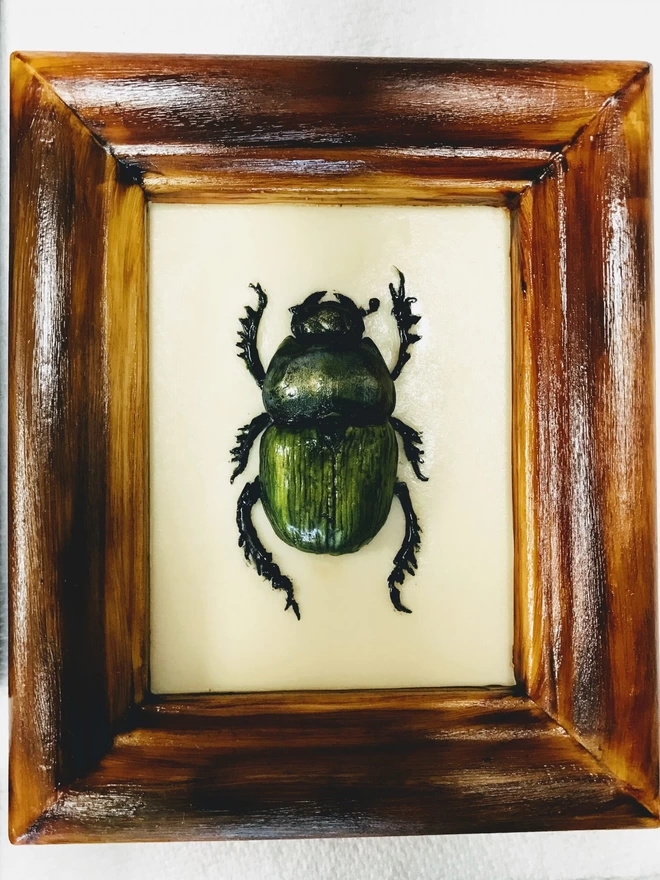 Realistic edible white chocolate dung beetle in chocolate frame