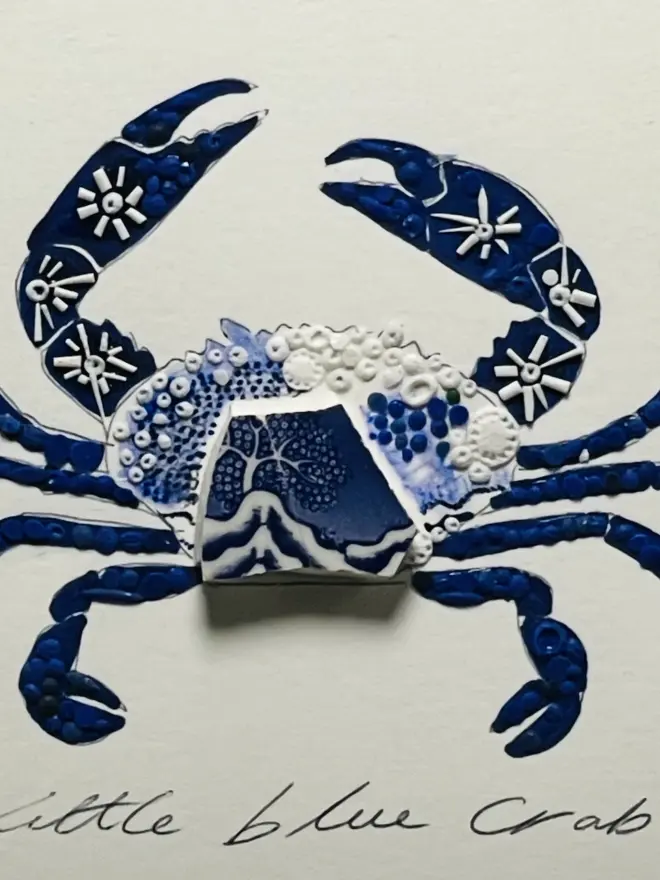 Hand-drawn, painted, mosaic clay, blue vintage Willow Tree pottery insect on white double mounted card, in a black circular frame.