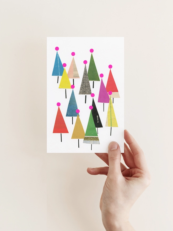 A bright Christmas card depicting a forest of colourful fir trees.