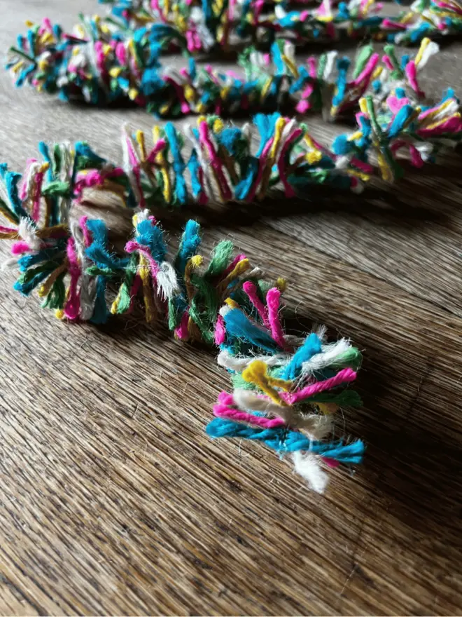 Neon Pop Strinsel draped on an oak table