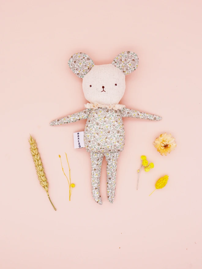 A handmade fabric doll in pastel floral prints, designed with distinct mouse features. This doll has a linen face, simple embroidered features, and delicate ruffled collars, showcasing their artisan craftsmanship.