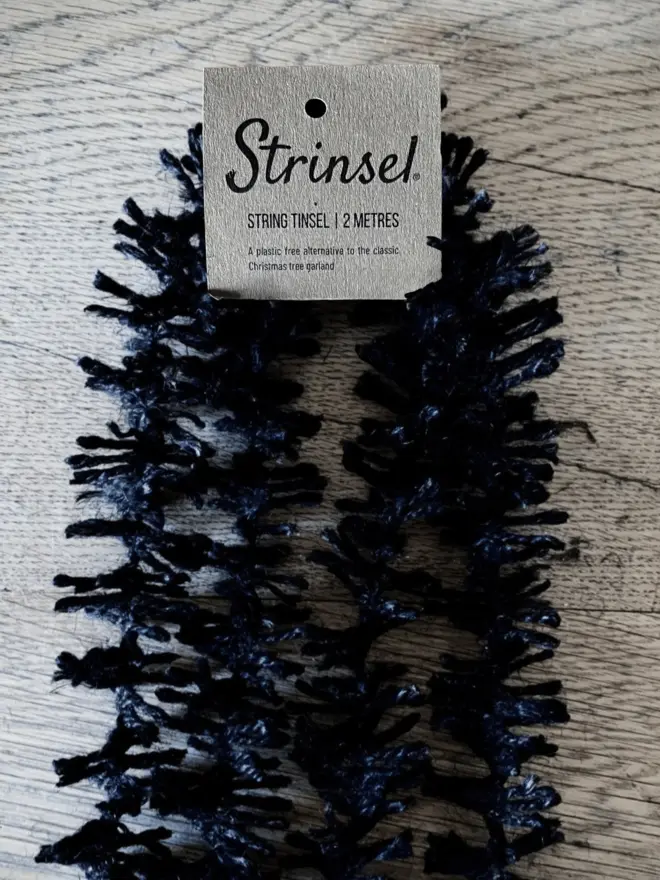 Spider Leg Strinsel with label AKA Jute string tinsel on an oak table