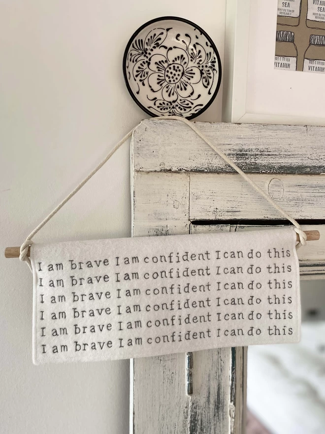 I Am Brave Felt Banner hanging on mirror with dish