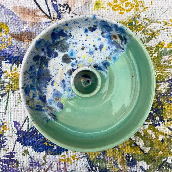 Shoreline Candle Stick Holder, a colourful candle stick holder sitting on a painted surface. 