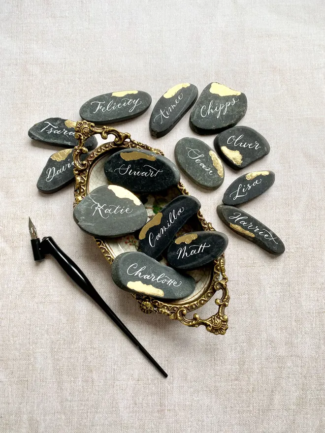 Wedding place cards written in calligraphy with gold leaf touches