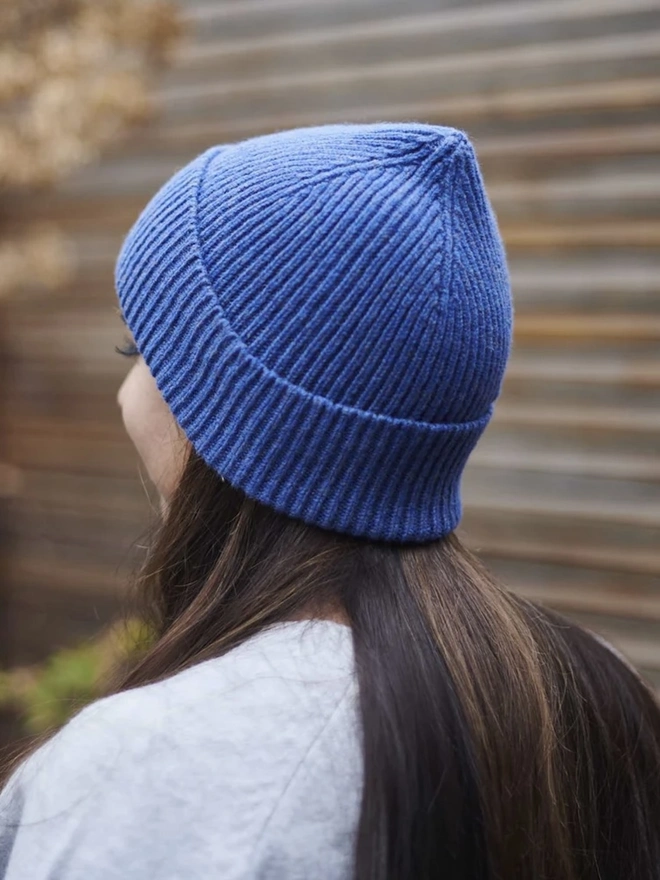 Ribbed Lambswool Women's Beanie, a woman wearing a colourful beanie outdoors. 