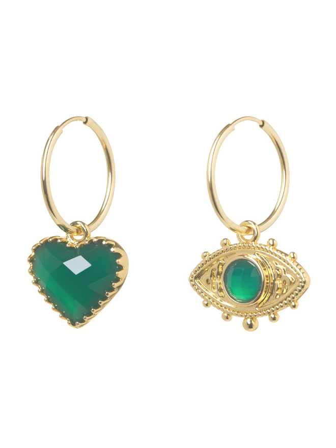 Pair of mismatching gold hoop earrings with a green faceted heart charm and a green evil eye charm on a white background