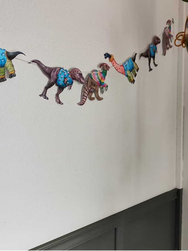 illustrated dinosaur garland. dinosaurs wearing jumpers on bunting.