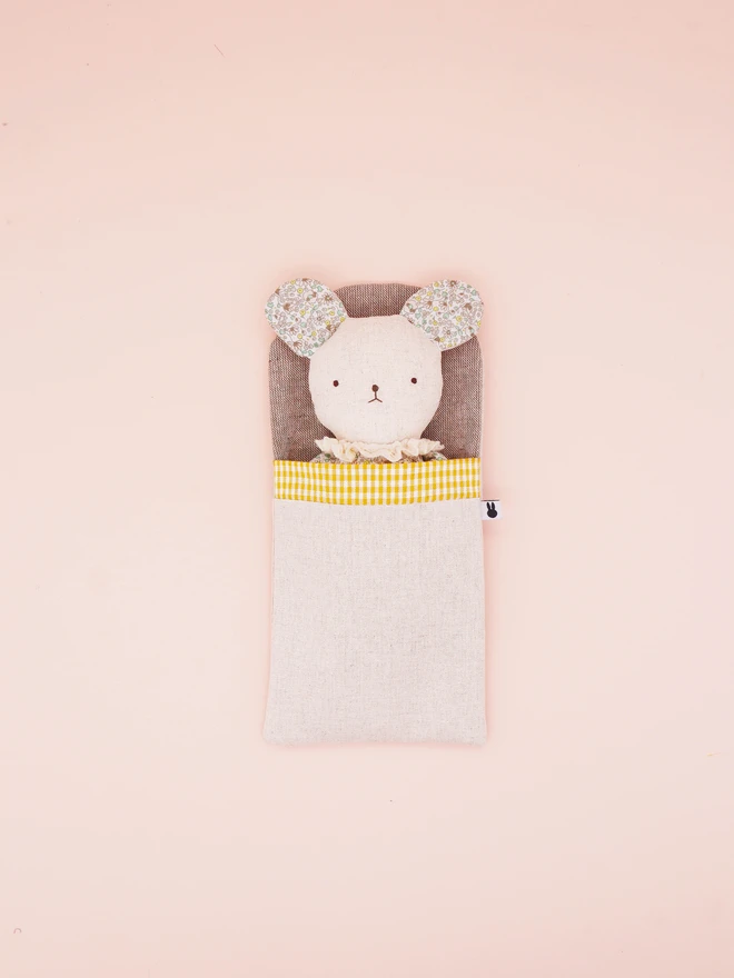 A handmade fabric doll in pastel floral prints, designed with distinct mouse features. This doll has a linen face, simple embroidered features, and delicate ruffled collars. With a handmade linen sleeping bag with yellow gingham trim.