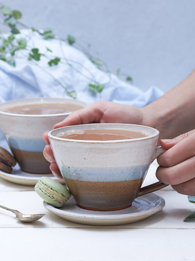 brown and white ceramic mug and saucer